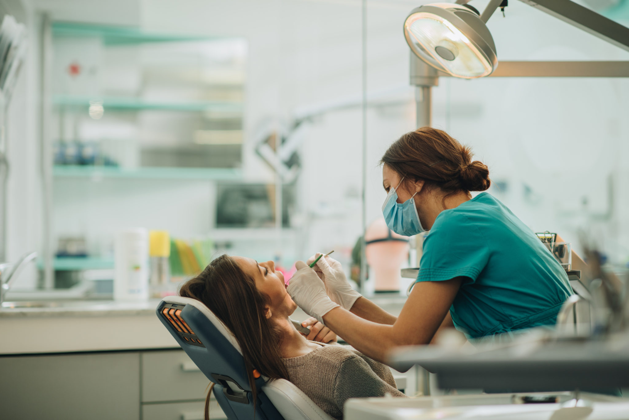 Young woman getting her teeth checked by female dentist